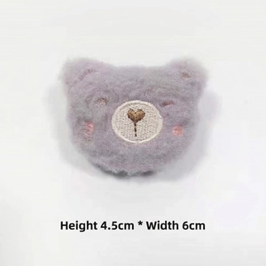 Detail view of a soft lavender plush bear head with heart embroidery, size 4.5x6cm
