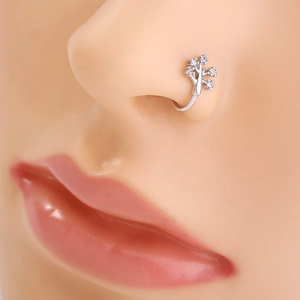 Detail view of silver stainless steel nose stud with tree shape and clear gemstones