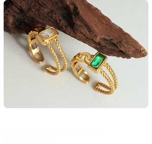 Detailed shot of gold plated titanium steel rings with emerald and clear zircon stones