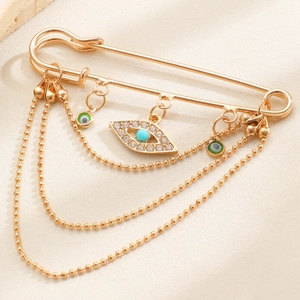 Detailansicht der Evil Eye Anhänger und goldenen Perlenketten an der Quasten Sicherheitsnadel