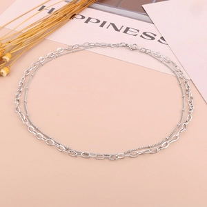 Detailed view of silver double-layered necklace with loop chain and bead chain on pink backdrop