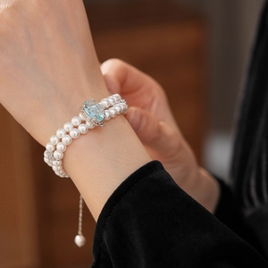 Détail du bracelet double rangée en perles avec pierre précieuse bleu clair et fermoir argent