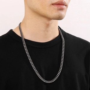 Gros plan d'une chaîne cubaine homme de 8mm en argent vintage sur un t-shirt noir