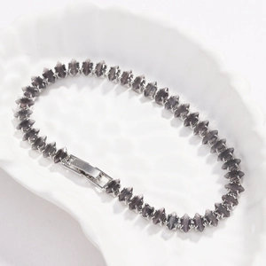 Primo piano di un bracciale tennis con pietre grigio fumo taglio marquise e chiusura