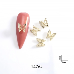 Close-up of gold hollow butterfly nail charms with size markings 8mm and 7mm