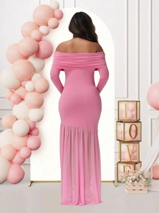 Rear view of pink off-shoulder maternity dress with mesh hem in a party setting