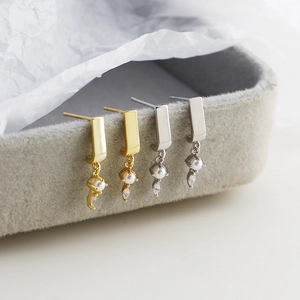 Macro detail of S925 silver earrings with pearls and diamonds in a grey velvet box