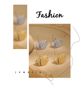 Détail des boucles d'oreilles feuille de ginkgo dorées et argentées en métal raffiné