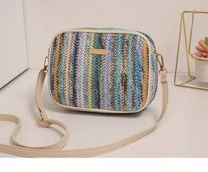 Detail of colorful woven straw crossbody bag with elegant gold metal hardware trim