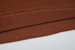 Macro detail of brown ribbed knit fabric with professional double-needle stitching