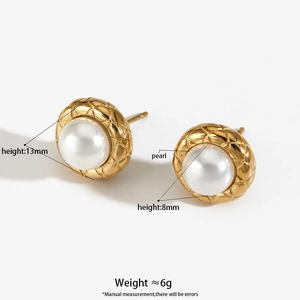 Golden stud earrings with large white pearls and quilted metal texture detail