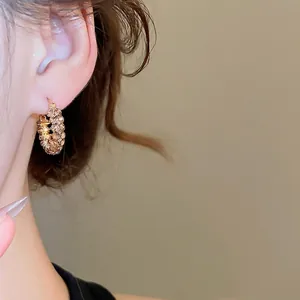 Elegante goldene geometrische Creolen mit glitzernden Strasssteinen am Modell