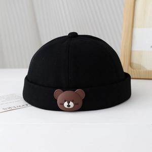 Gros plan du bonnet docker noir en coton avec un patch ours en silicone mignon