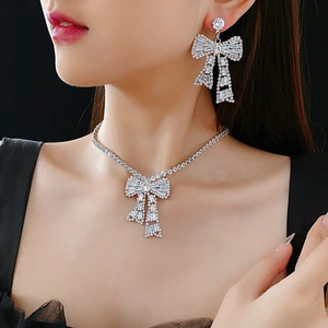 Close-up of elegant bow-shaped rhinestone necklace and earrings set on a model