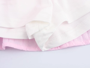 Detailed macro view showing precision stitching on white and pink layered ruffles