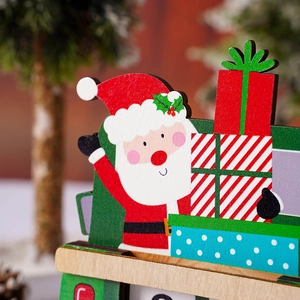 Close-up of Santa Claus on a green wooden truck with gift boxes and festive background