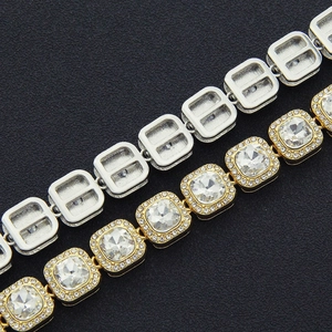 Detail of gold and silver hip hop cuban link chains with square cubic zirconia on black background
