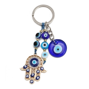 Golden Evil Eye keychain featuring a Hamsa Hand charm and blue glass beads on white backdrop