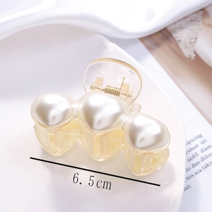Detail view of 6.5cm hair claw clip with three large pearls on cream base