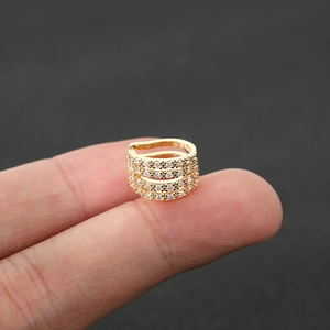 Detailed close-up of a four-layer gold ear cuff with sparkling pavé zircon stones