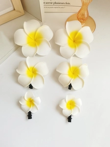 Detail of frangipani hair clips in three sizes with realistic white and yellow petals