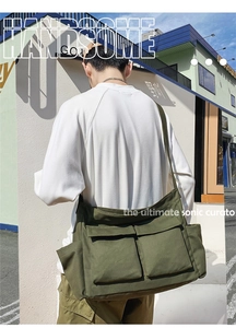 Detail view of olive green canvas messenger bag with large front utility pockets