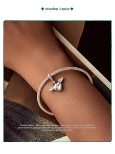 Close-up of S925 sterling silver heart-shaped wing pendant on a woven bracelet