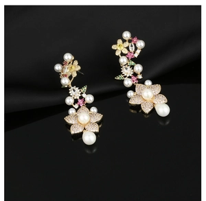 Detail of floral earrings with sparkling colorful zircons and drop pearls on black silk
