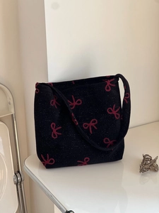 Knitted tote bag in black with red bow embroidery and glitter metallic yarn finish