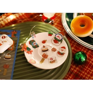 Close-up of cute Christmas PET stickers on a decorative plate for DIY craft decoration