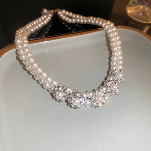 Detail of elegant double-layer pearl necklace with sparkling floral diamond centerpiece