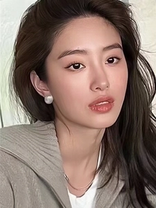 Close-up of elegant brushed metal sphere earrings worn by a model in a portrait shot