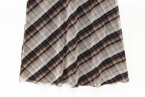 Macro detail of brown and cream plaid mesh fabric showing fine texture and hemline