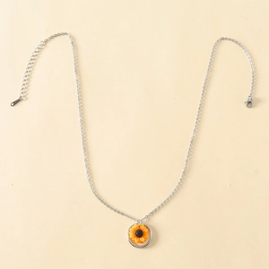 Close-up of a silver sunflower pendant necklace with yellow petals and a metallic border