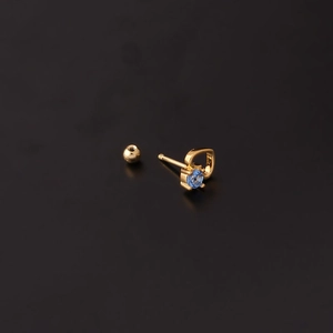Macro shot of gold heart stud earring with blue zircon stone and screw back closure