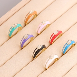 Dettaglio di anelli in smalto colorato placcati oro con zirconi brillanti