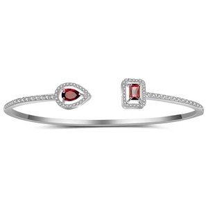 Detail of silver open bangle featuring pear and emerald cut red stones with zircon halo