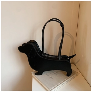 Detailed view of creative dachshund shaped black shoulder bag on an artistic book prop