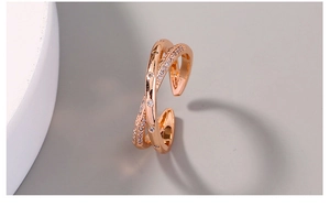 Macro shot of rose gold plated crisscross ring with cubic zirconia on stone background