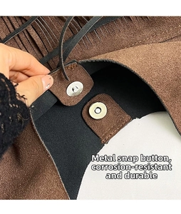 Close-up of the silver magnetic closure on a brown faux suede fringe tote bag