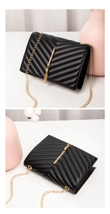 Detail of black quilted leather crossbody bag with gold chain and tassel hardware