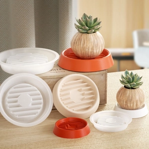 Macro shot of striped round resin coasters and planter trays in white and orange