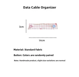 Pink checkered fabric cable organizer wrap measuring 14cm x 3cm with snap button