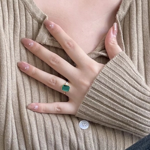 925 silver gold plated ring with emerald cut green stone and side diamonds on hand