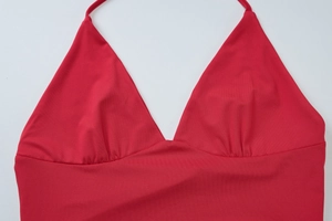 Détail à plat d'un haut licou rouge avec col en V et tissu extensible de qualité