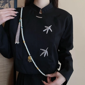 Detail of multi-layer pearl body chain with pink tassel and golden lotus pendant