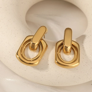Polished gold geometric interlocking earrings with rectangular charm on white silk