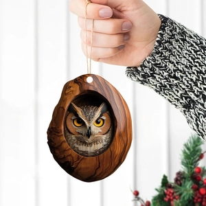 Detail of 2D acrylic owl ornament with wood texture hanging on a decorated Christmas tree