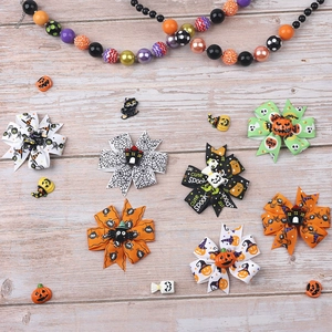 Flat lay of Halloween hair clips with pumpkin, spider web, and ghost patterns on wood