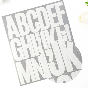 Macro shot of 3-inch white waterproof letter stickers with realistic water droplets detail
